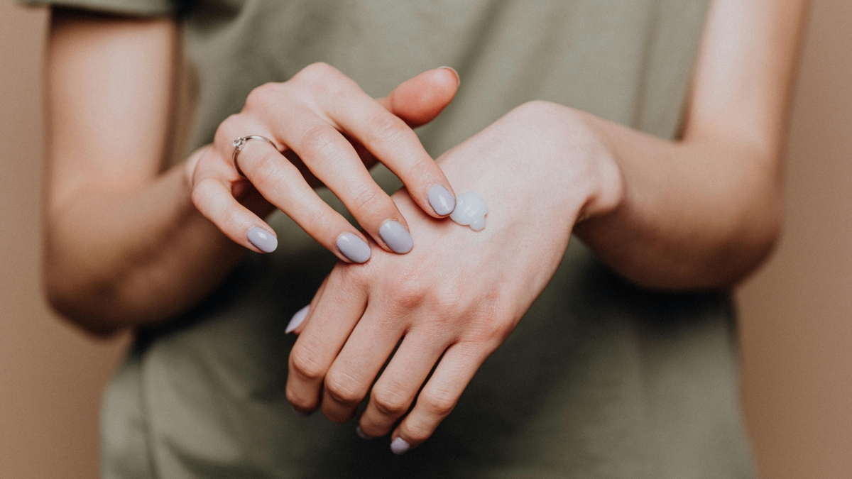 woman applying moisturizer to her hands